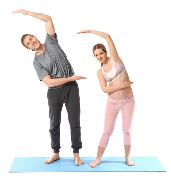 Genç Hamile Kadın Kocası Beyaz Arka Planda Yoga Yapıyorlar — Stok fotoğraf