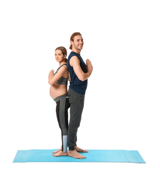 Junge Schwangere Frau Und Ihr Mann Praktizieren Yoga Auf Weißem — Stockfoto