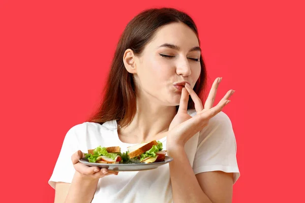 Jonge Vrouw Eten Smakelijke Sandwich Kleur Achtergrond — Stockfoto