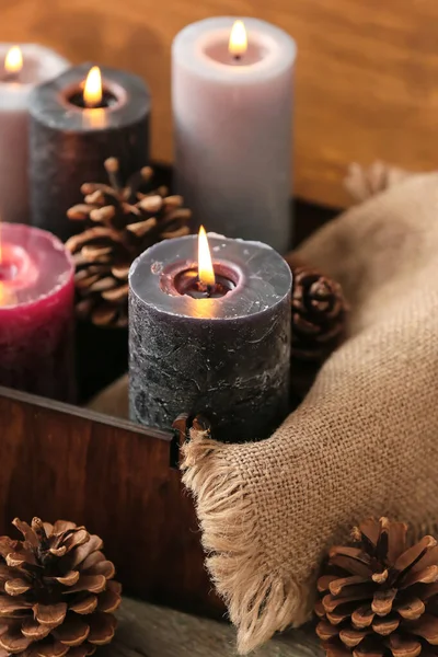 木制盒子和松果中燃烧着美丽的蜡烛 — 图库照片