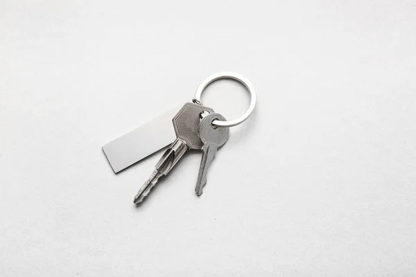 浅色背景的带有时髦钥匙链的钥匙 — 图库照片