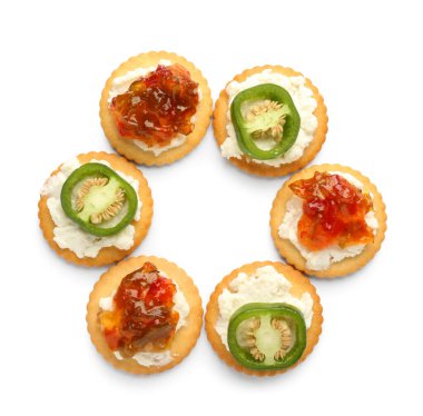 Süzme peynirli lezzetli krakerler ve beyaz arka planda jalapeno biber reçeli.