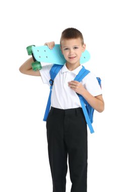 Beyaz arka planda kaykayı olan tatlı bir okul çocuğu.