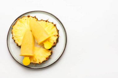 Beyaz arka planda lezzetli ananaslı dondurma tabağı.