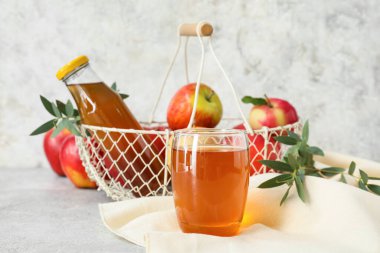 Hafif arkaplanda bir bardak elma suyu.