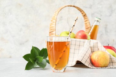 Hafif arkaplanda bir bardak elma suyu.