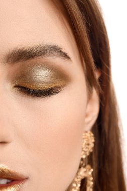 Beyaz arka planda altın makyajlı güzel bir genç kadın, yakın plan.