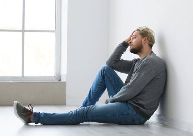 Depresyondaki genç adam boş odada