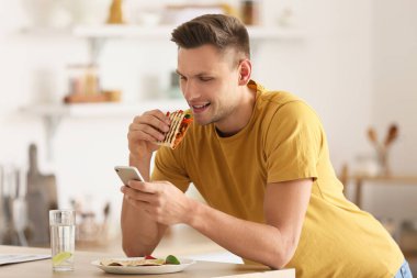 Evde lezzetli quesadilla yiyen yakışıklı genç adam.