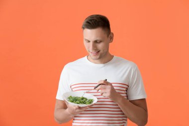 Renkli mantı yiyen yakışıklı genç adam.