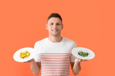 Farklı renkte ravioli tabakları olan yakışıklı genç bir adam.