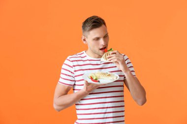 Genç adam arka planda lezzetli quesadilla yiyor.