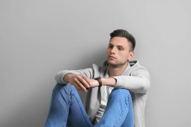 Gri arka planda depresif genç adam