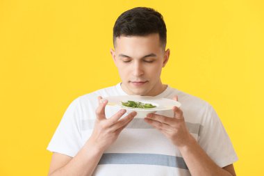 Renkli mantı tabağı olan yakışıklı bir genç adam.