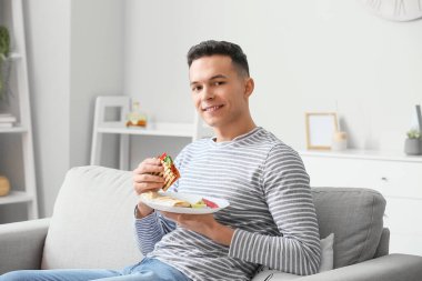 Evde lezzetli quesadilla yiyen yakışıklı genç adam.