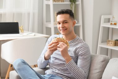 Evde lezzetli quesadilla yiyen yakışıklı genç adam.