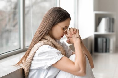 Dua eden genç bayan ofiste.