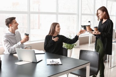 İş arkadaşları ofiste kahve içiyor.