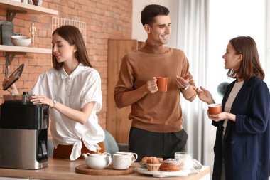 İş arkadaşları ofiste kahve içiyor.