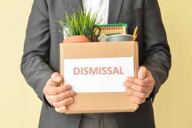 Renkli arka planda kişisel eşyaları olan kovulmuş işçi