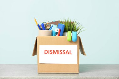 Renk duvarının yanındaki masada kişisel eşyalarla dolu bir kutu.