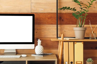 Ahşap duvarın yanında bilgisayarı olan modern bir işyeri