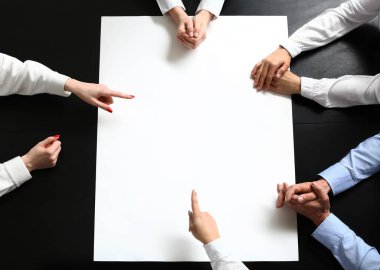 Masasında boş posteri olan bir grup insan.