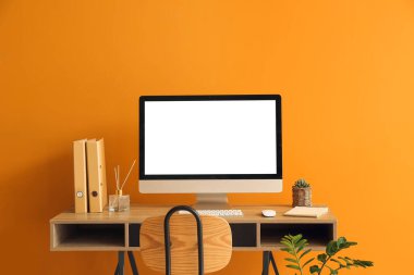 Renk duvarına yakın bilgisayarı olan modern işyeri
