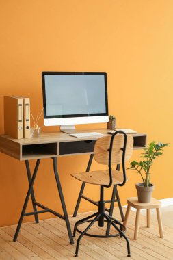 Renk duvarına yakın bilgisayarı olan modern işyeri