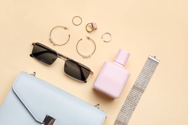 Arka planda parfüm şişesi olan kadın aksesuarları.