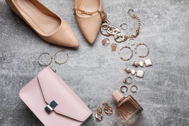 Kadın aksesuarları, ayakkabılar ve bir şişe parfümle yapılmış çerçeve.