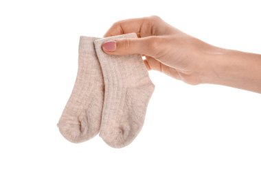 Beyaz arka planda bebek çorapları tutan kadın.