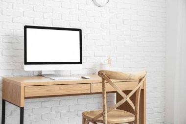 Tuğla duvarın yanında bilgisayarı olan modern işyeri