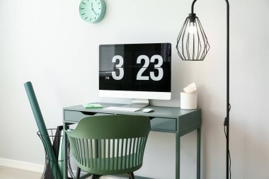 Işık duvarına yakın bilgisayarı olan modern işyeri