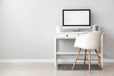 Işık duvarına yakın bilgisayarı olan modern işyeri