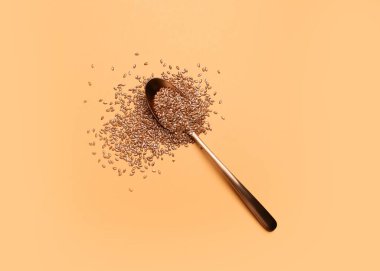 Renk arkaplanında keten tohumlu kaşık