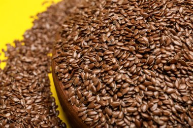 Renk arkaplanında keten tohumları olan kase, yakın plan