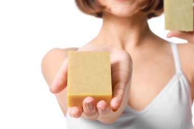 Beyaz arka planda sabunu olan güzel genç bir kadın.