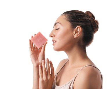 Beyaz arka planda sabunu olan güzel genç bir kadın.