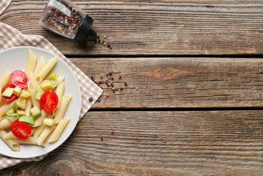 Ahşap arka planda sebzeli lezzetli makarna, yakın plan.