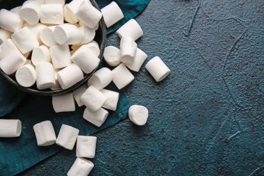 Koyu arkaplanda lezzetli şekerlemelerle dolu bir kase.