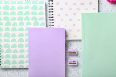 Defterler ve kalemtraşlar masaya, yakın plan.