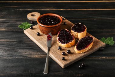 Koyu ahşap arka planda siyah frenk üzümü reçeli tostları