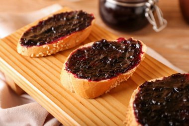 Ahşap arka planda siyah frenk üzümü reçelli tostlar