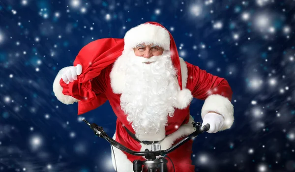 Papai Noel Com Saco Andar Bicicleta Fundo Cor Escura — Fotografia de Stock