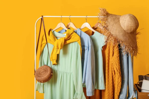 Renkli arka planda şık kıyafetler ve aksesuarlarla dizin