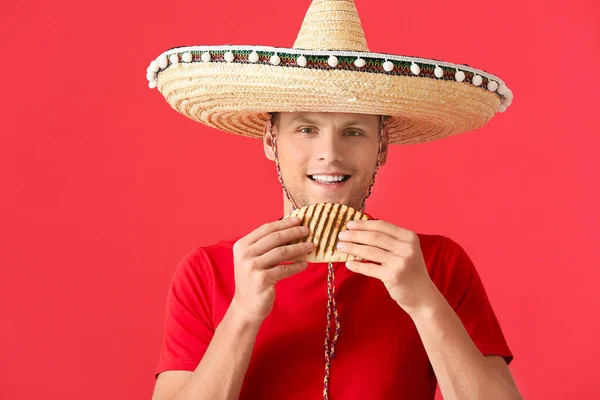 Junger Mexikanischer Mann Isst Leckere Quesadilla Auf Farbigem Hintergrund — Stockfoto