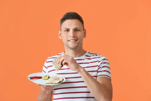 Young Man Eating Tasty Quesadilla Color Background — Stock Photo, Image