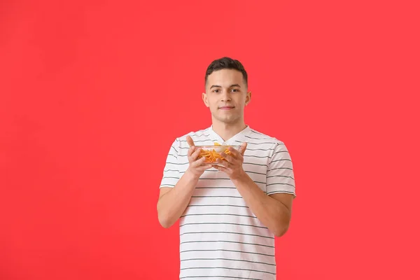 Joven Guapo Con Sabrosos Nachos Sobre Fondo Color —  Fotos de Stock