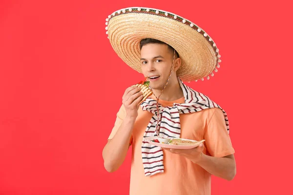 Junger Mexikanischer Mann Isst Leckere Quesadilla Auf Farbigem Hintergrund — Stockfoto